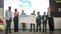 Learners holding a cheque on stage with their teacher and a representative of the JSE. The learners are the winners of the JSE investment challenge.