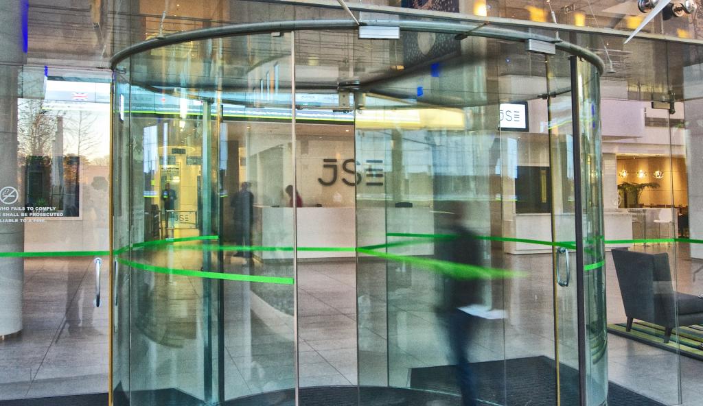 The entryway to the JSE Limited building located at Exchange Square in Johannesburg, with an individual passing through the turnstile at the entrance.